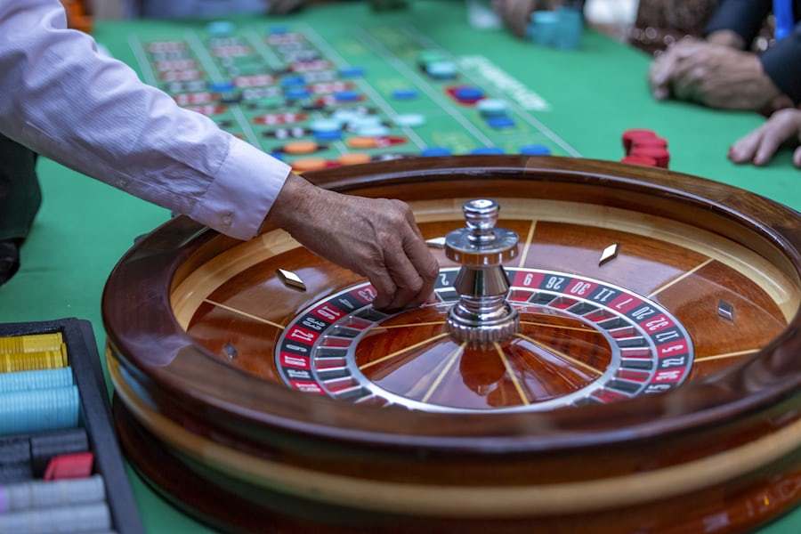 Suasana lantai kasino dengan meja permainan yang terang benderang